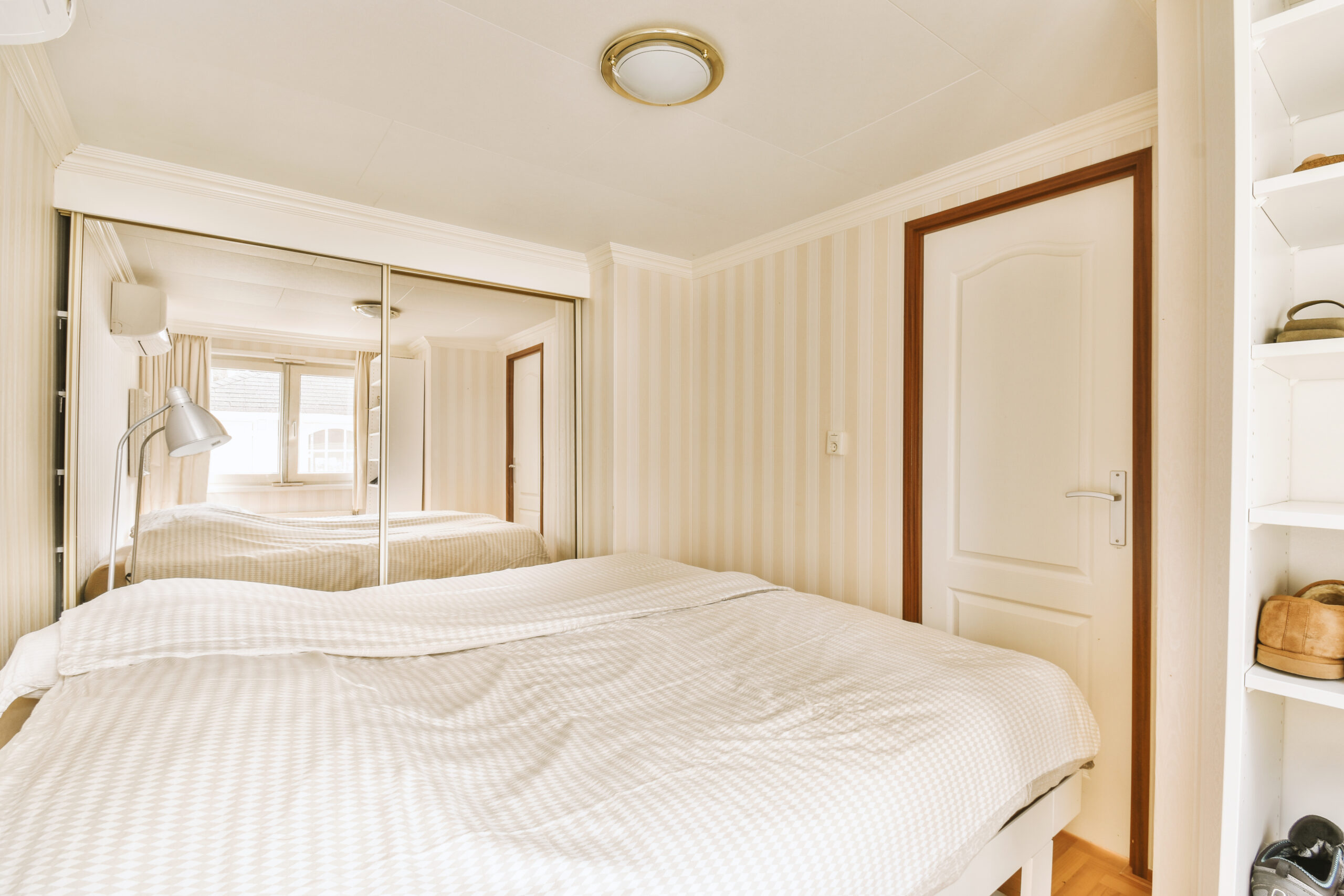 a bedroom with a large white bed and a mirror
